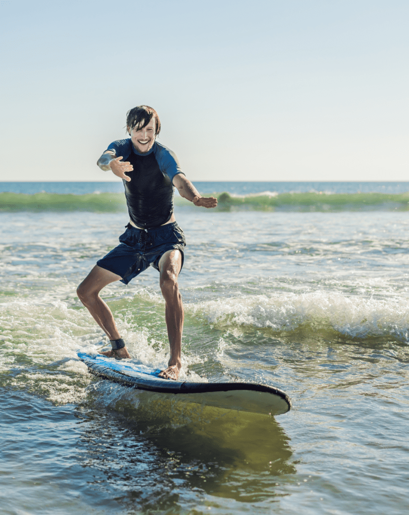 young-man-beginner-surfer-learns-surf-sea-foam-bali-island-1-813x1024